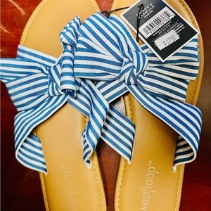 Blue and white fabric flats with bow and comfort foot padding.